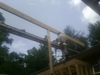 Carpenter setting a ridge beam over a new addition frame — Ice Dam Removal by Roofing Brothers in Fremont